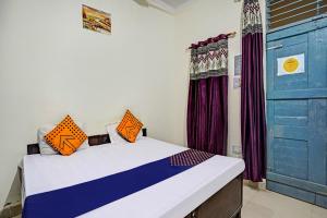 a room with a bed and a blue door at OYO Hotel Jmd Residency in Shahdara