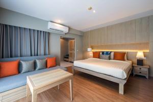 1 dormitorio con 1 cama y 1 sofá en Aonang All Seasons Beach Resort en Ao Nang Beach