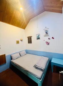 a bed in a room with a blue and white wall at 84 April Real Home in Plei Groi