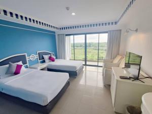 pokój hotelowy z 2 łóżkami i telewizorem w obiekcie Rua Rasada Express w mieście Trang
