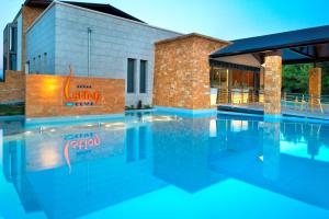 a swimming pool in front of a building at Istion Club & Spa in Nea Potidaea