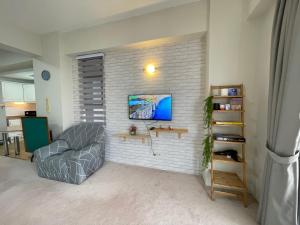 una sala de estar con una pared de ladrillo blanco en Cosy Music Home at Genting View Resort 3R2B 9pax by Jen dehome, en Genting Highlands
