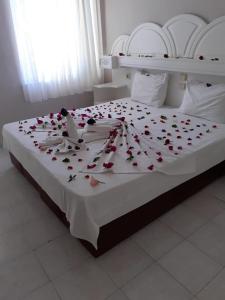 a bed with red roses on top of it at meryemana hotel in Didim