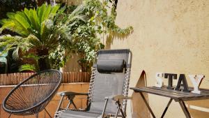 een stoel en een tafel met een bord waarop staat: blijf bij apartment next to park guell in Barcelona