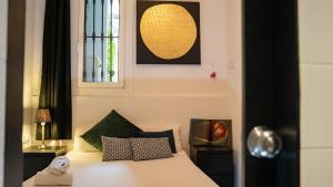 a bedroom with a white bed with a window at apartment next to park guell in Barcelona