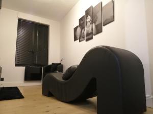 a black chair in a room with a window at La Maison Coquine in Béthune