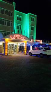 SANCAK HOTEL في بيوك شكمجه: سيارة بيضاء متوقفة أمام الفندق في مكان منعزل