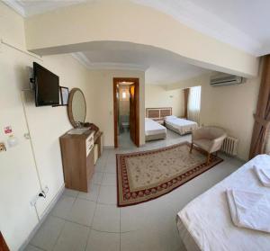 ein Hotelzimmer mit einem Schlafzimmer mit einem Bett und einem TV in der Unterkunft SANCAK HOTEL in Büyükçekmece