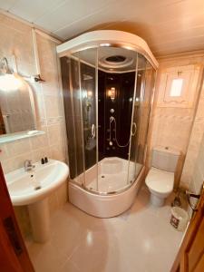 a bathroom with a shower and a toilet and a sink at SANCAK HOTEL in Büyükçekmece