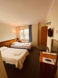 Habitación de hotel con 2 camas y TV en SANCAK HOTEL en Buyukcekmece