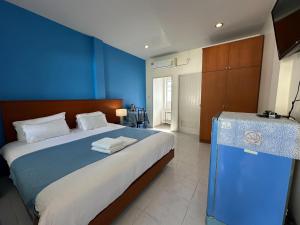 1 dormitorio con 1 cama grande y pared azul en Grandma Kaew House, en Chiang Rai
