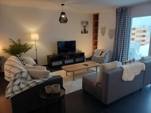 ein Wohnzimmer mit 2 Sofas und einem TV in der Unterkunft Spacieux appart 3,5 pièces incl Jaccuzzi Privé in Leukerbad