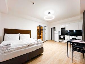 a bedroom with a large bed and a kitchen at Post 120 Suites in Prague