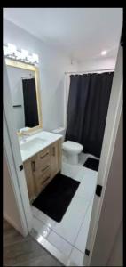 a bathroom with a sink and a toilet and a mirror at Cozy in Regina