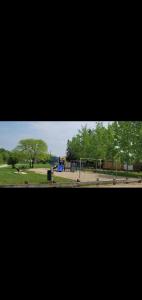 Blick auf einen Park mit Spielplatz in der Unterkunft Cozy in Regina