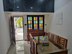 una sala da pranzo con tavolo e vetrata colorata di Woodside Haven a Chegāt