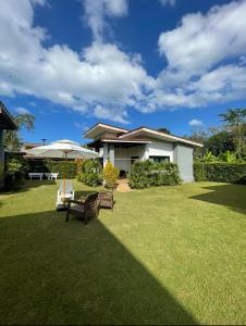 a house with a lawn with a bench and an umbrella at KhaoLak Chill Out in Khao Lak
