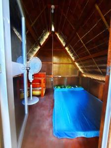 Habitación pequeña con cama y ventilador. en Destiny Rainbow Beach Resort en Siquijor
