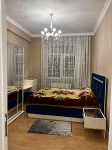a bedroom with a bed and a chandelier at Apartment Samir mida in Baku
