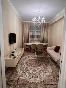 salon z kanapą i stołem w obiekcie Apartment Samir mida w mieście Baku