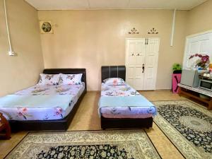 1 Schlafzimmer mit 2 Betten und einer Tür in der Unterkunft COZY GL Roomstay ARAU in Kangar