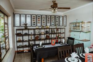 uma sala de jantar com uma mesa e uma prateleira de itens em Ons Dorpshuis Guesthouse em Rustenburg