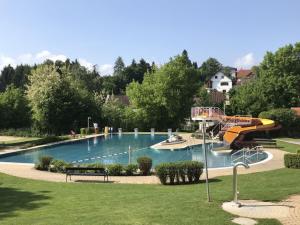 a large swimming pool with a slide in a park at Nina´s Home in Gablitz