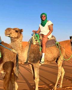 メルズーガにあるMerry Desert Campの砂漠のラクダの上に座る女