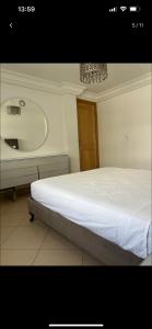 a bedroom with a bed and a sink and a mirror at Duplex corniche lac 2 in Tunis