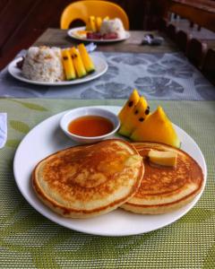 Un plato con panqueques y otros alimentos en una mesa. en Neela Tourist Lodge, en El Nido