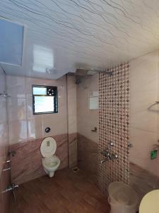 een badkamer met een toilet en een douche bij Hotel Oneness Palace in Mahabaleshwar