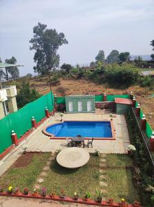 a backyard with a swimming pool and a table at Hotel Oneness Palace in Mahabaleshwar