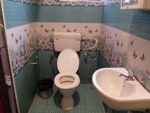 y baño con aseo y lavamanos. en FLGHR Crazy Home Stay en Kodaikānāl