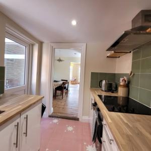 a kitchen with a counter top and a dining room at Pea Cottage in Kessingland