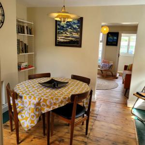 a dining room table with a yellow and white table cloth at Pea Cottage in Kessingland