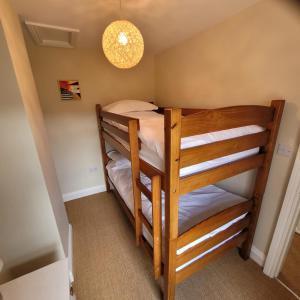 a bunk room with two bunk beds in it at Pea Cottage in Kessingland