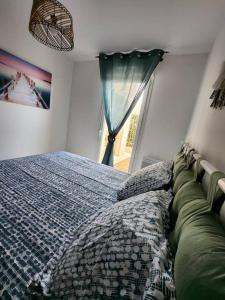 Schlafzimmer mit einem Bett und einem Fenster in der Unterkunft Appartement idéalement situé - la Seyne sur mer in La Seyne-sur-Mer