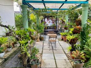 a patio with tables and plants in a greenhouse at COZY GL Roomstay ARAU in Kangar