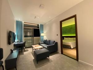 a living room with a couch and a bed and a mirror at NEWCC HOTEL AND SERVICED APARTMENT in Quang Ngai