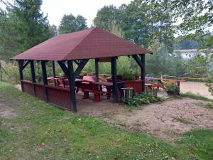 a gazebo with a picnic table in a park at Domek Golf i Jezioro in Tomaszkowo