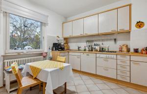 a kitchen with white cabinets and a table and a window at Lovely Apartment In Jena With Wifi in Jena +12 photos