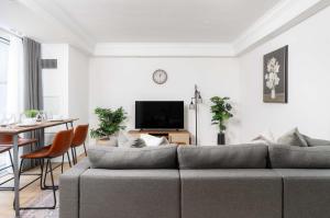a living room with a gray couch and a table at Stunning 2BR + 2.5BA Luxury Townhome Steps from Square One! in Mississauga