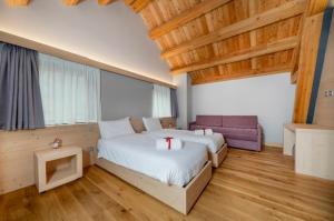 a large bedroom with two beds and a couch at Kile Alpine Resort in Valbruna