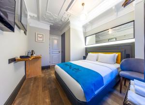 a bedroom with a king sized bed and a blue chair at Taksim Avenue in Istanbul