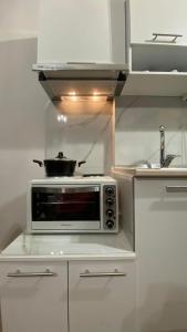 Una cocina con un microondas con una sartén encima. en Bed & Business, en Drama