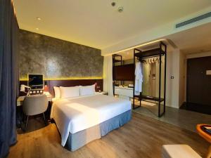 a hotel room with a large bed and a desk at NEWCC HOTEL AND SERVICED APARTMENT in Quang Ngai