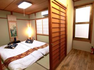 two beds in a room with two windows at 稲荷 かおり in Kyoto