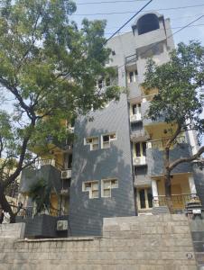 un grand bâtiment avec des arbres devant lui dans l'établissement A.R Residency, à Chennai