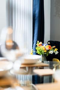 einen Tisch mit einer Blumenvase drauf in der Unterkunft Amazing Family Apartment, Sleeps 6, Cot, Work desk in Birmingham