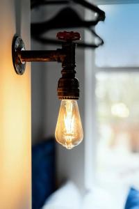 une ampoule suspendue à un gabarit lumineux noir dans l'établissement Amazing Family Apartment, Sleeps 6, Cot, Work desk, à Birmingham